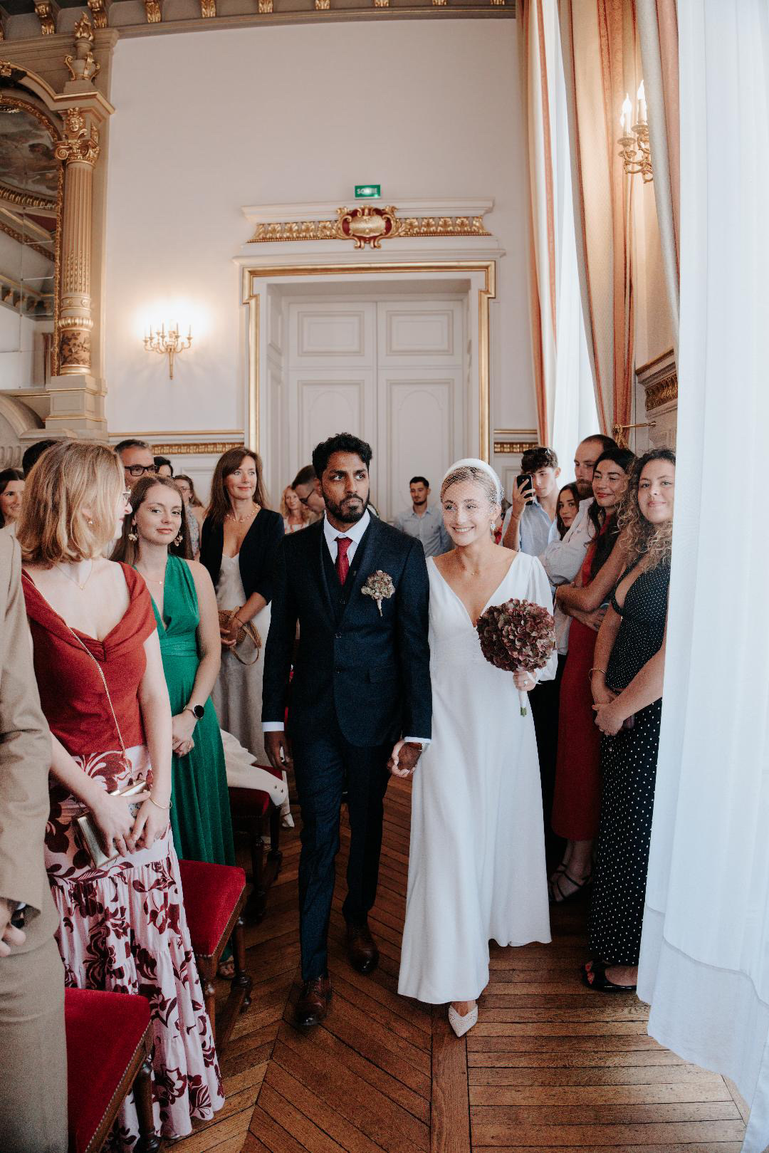 Farhaaz et Esther main dans la main pendant leur mariage à Limoges, entourés de leurs proches
