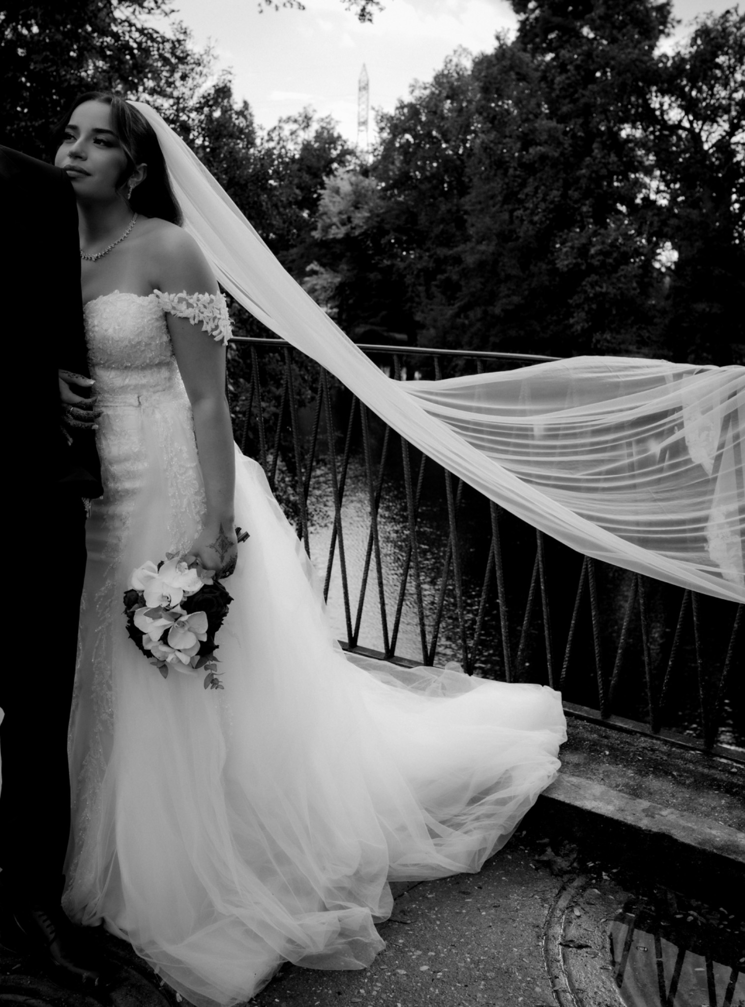 Mariée et long voile en mouvement sur un pont