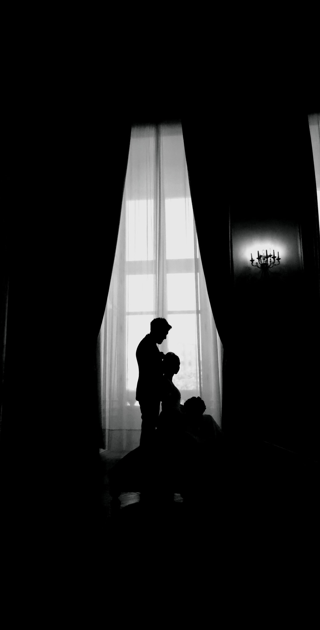Silhouettes de Farhaaz et Esther en noir et blanc devant une grande fenêtre